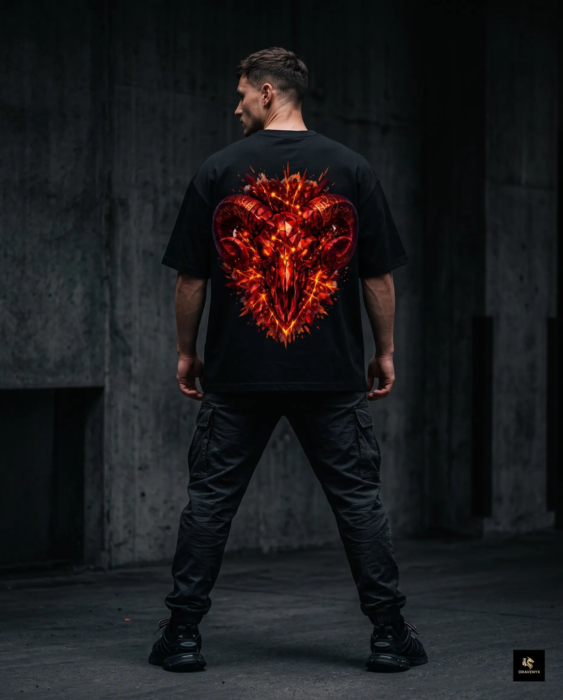 DRAVENYX® Aries Infernal Ram Oversized Tee in Black — front view featuring left-chest crystalline Aries wing-mark emblem in molten amber and iron tones — back view showing full DTF print of infernal crystal ram skull with rune-inscribed curling horns and golden ember burst