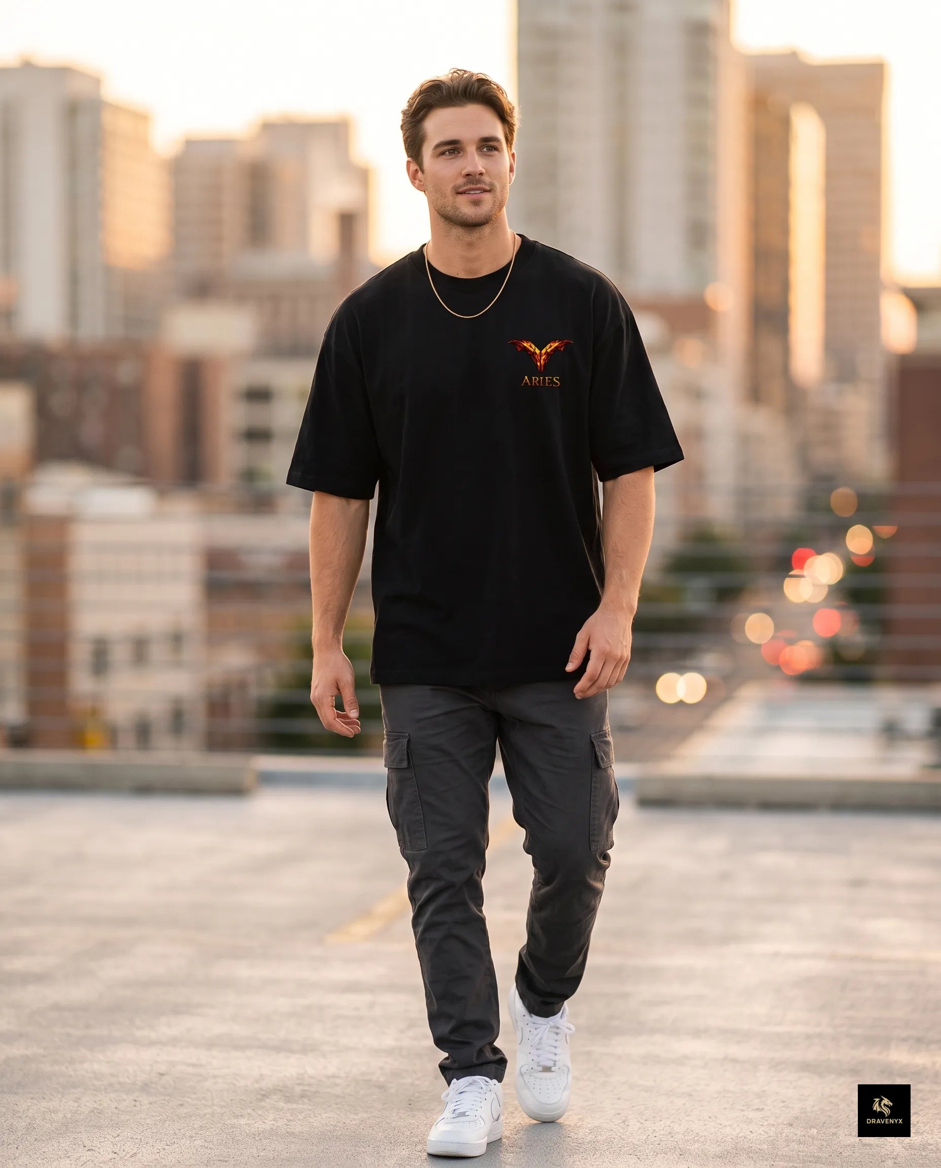 DRAVENYX® Aries Infernal Ram Oversized Tee in Black — front view featuring left-chest crystalline Aries wing-mark emblem in molten amber and iron tones — back view showing full DTF print of infernal crystal ram skull with rune-inscribed curling horns and golden ember burst