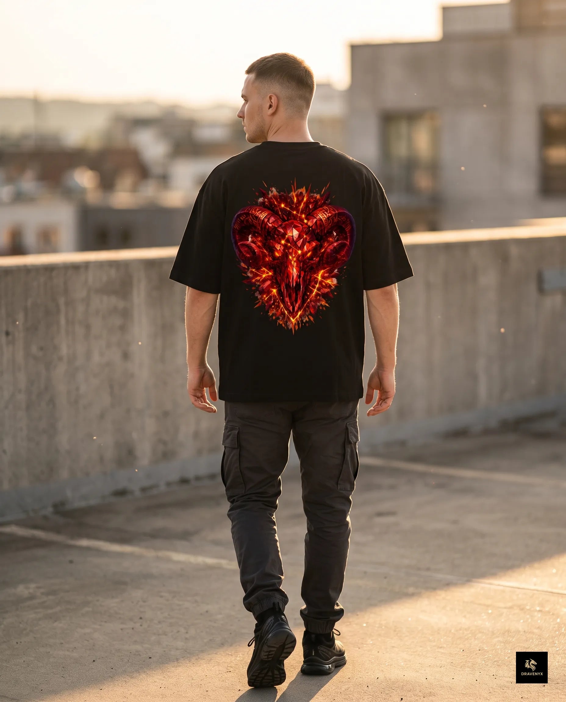 DRAVENYX® Aries Infernal Ram Oversized Tee in Black — front view featuring left-chest crystalline Aries wing-mark emblem in molten amber and iron tones — back view showing full DTF print of infernal crystal ram skull with rune-inscribed curling horns and golden ember burst