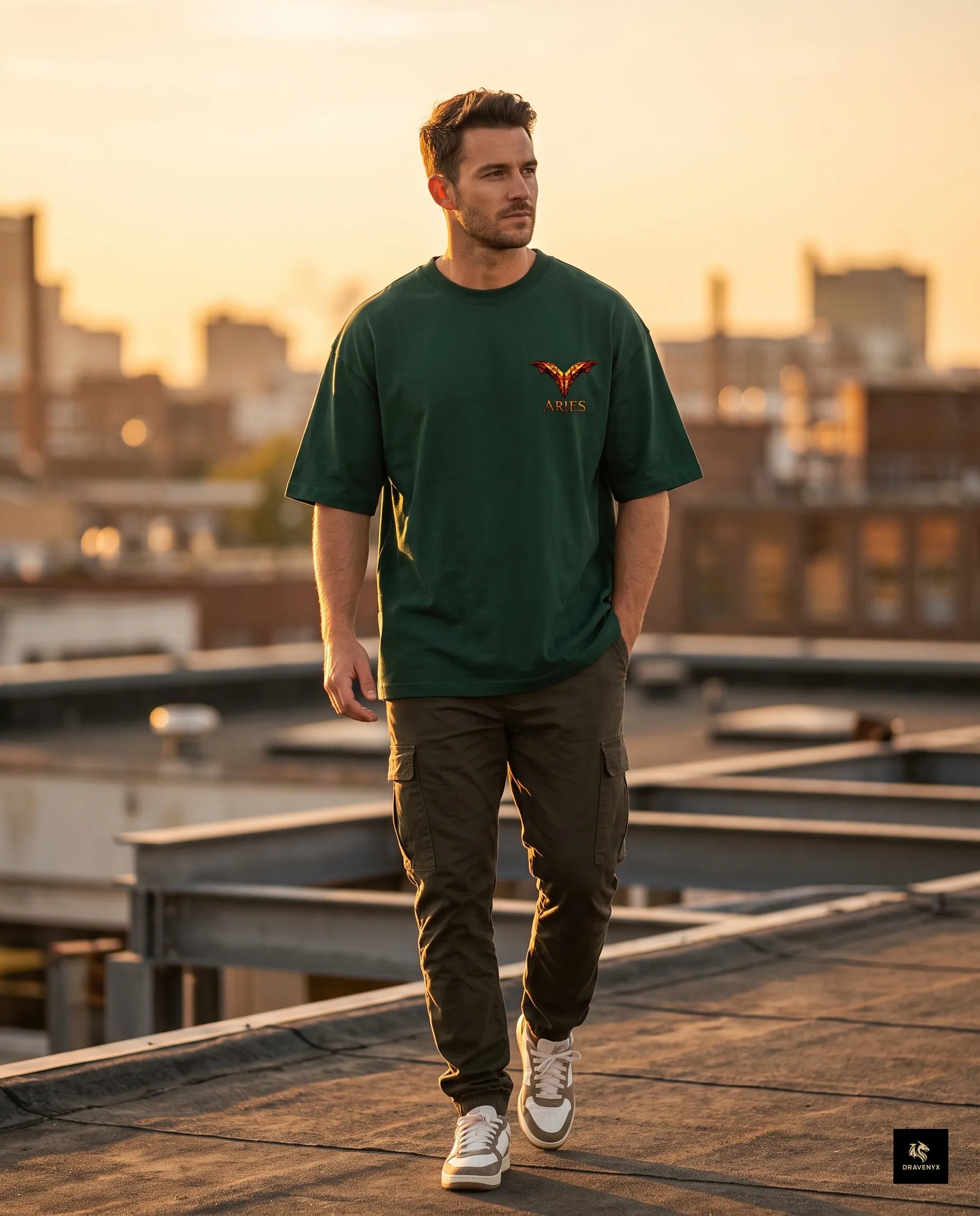 DRAVENYX® Aries Infernal Ram Oversized Tee in Bottle Green — front view featuring left-chest crystalline Aries wing-mark emblem in molten amber and iron tones — back view showing full DTF print of infernal crystal ram skull with rune-inscribed curling horns and golden ember burst