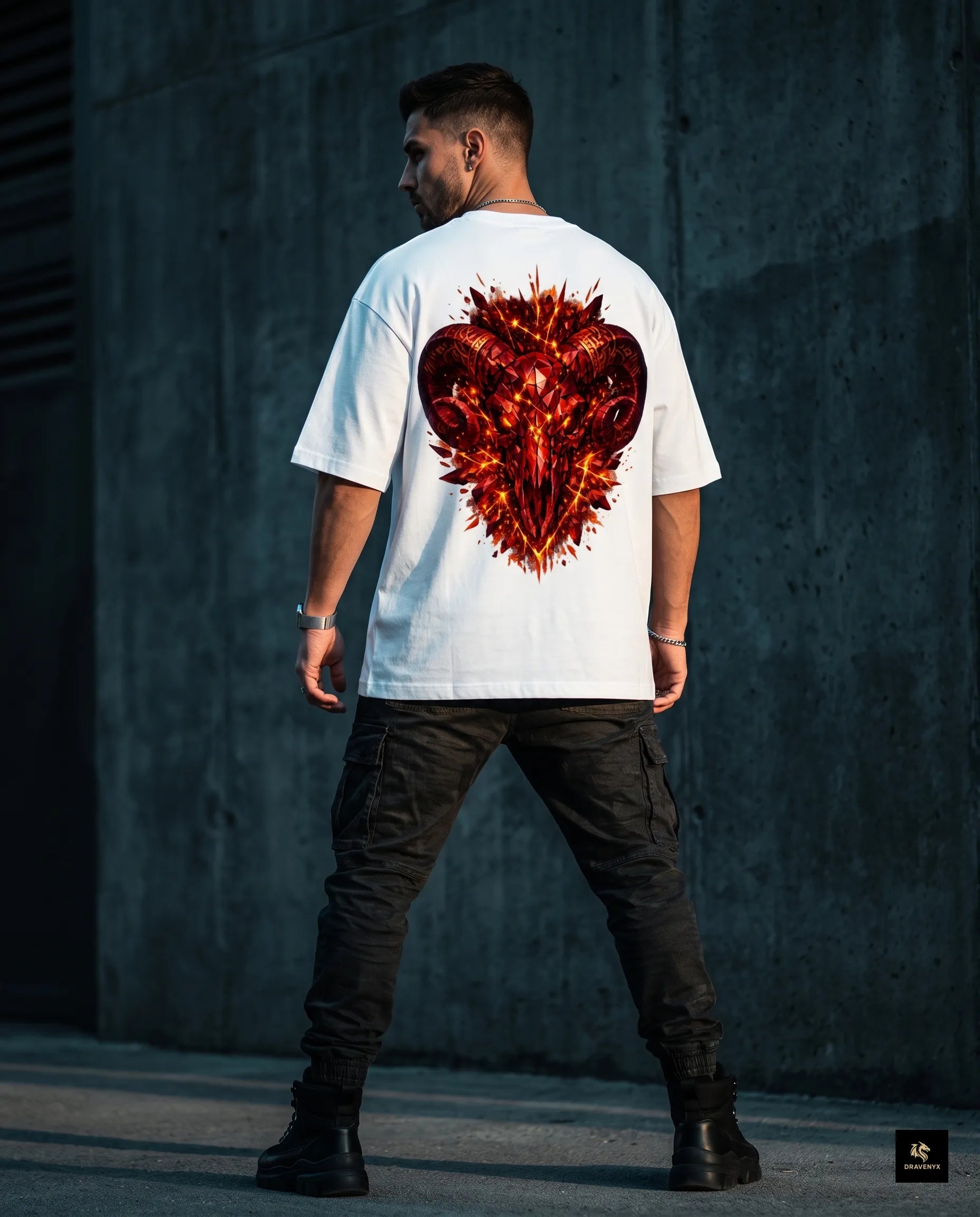 DRAVENYX® Aries Infernal Ram Oversized Tee in White — front view featuring left-chest crystalline Aries wing-mark emblem in molten amber and iron tones — back view showing full DTF print of infernal crystal ram skull with rune-inscribed curling horns and golden ember burst