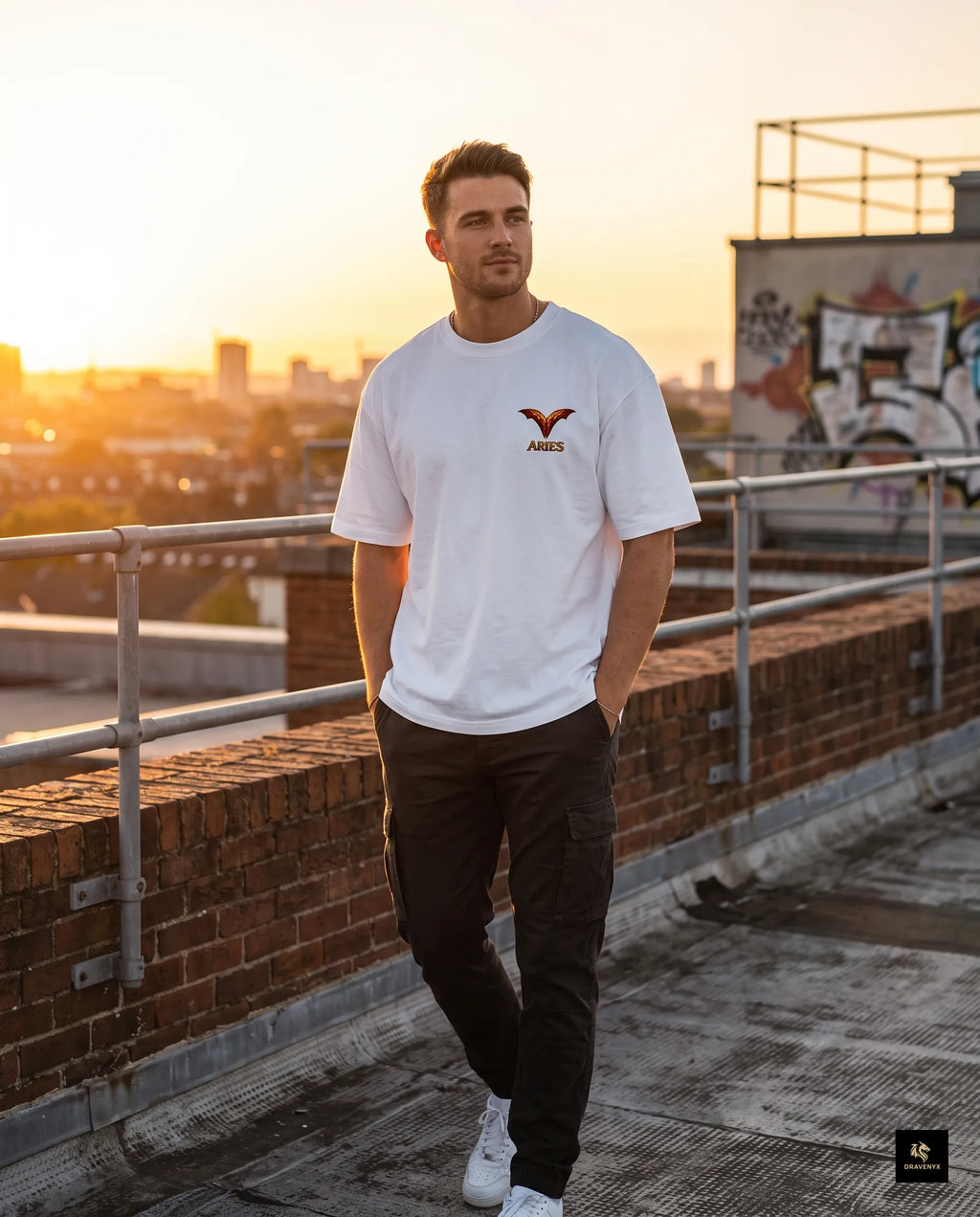 DRAVENYX® Aries Infernal Ram Oversized Tee in White — front view featuring left-chest crystalline Aries wing-mark emblem in molten amber and iron tones — back view showing full DTF print of infernal crystal ram skull with rune-inscribed curling horns and golden ember burst