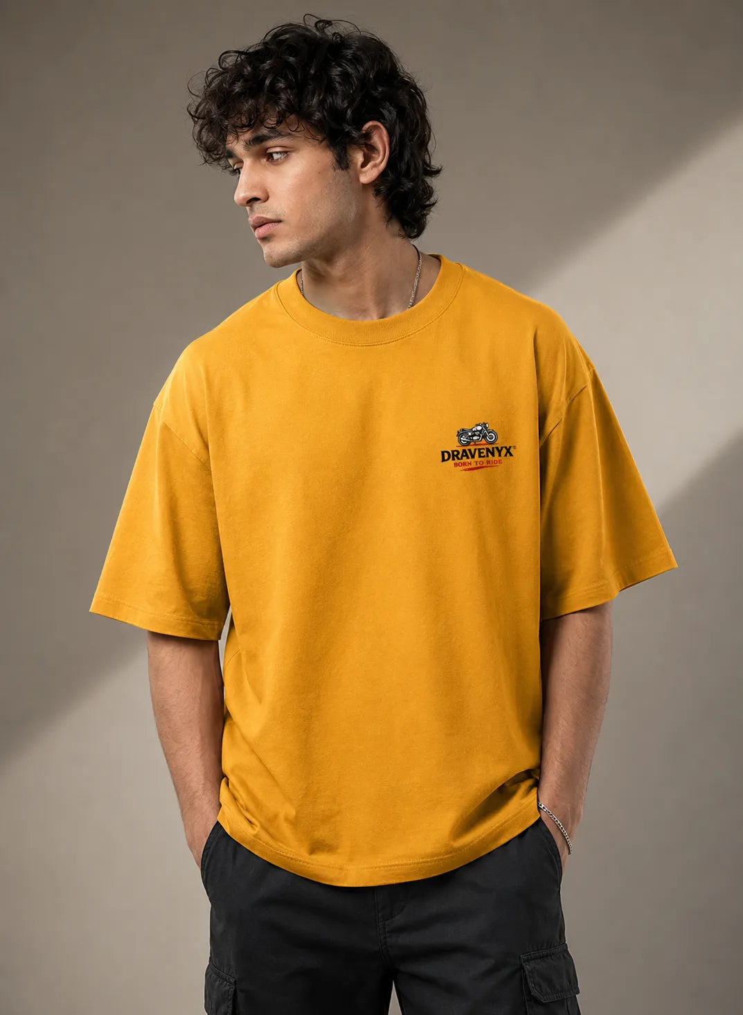 DRAVENYX® Born To Ride oversized tee in Golden Yellow — front view showing left chest moto-badge print and drop-shoulder silhouette — back view with full-panel moto-art graphic and 'Born To Ride / Built For Freedom' DTF print