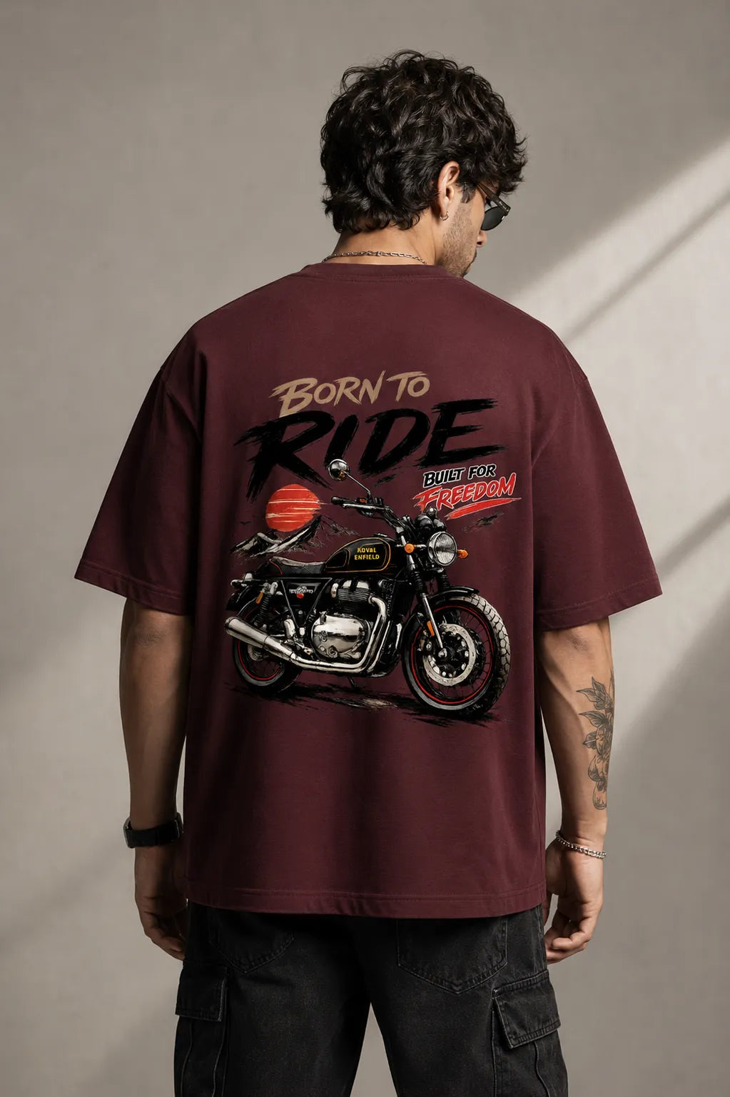 DRAVENYX® Born To Ride oversized tee in Maroon — front view showing left chest moto-badge print and drop-shoulder silhouette — back view with full-panel moto-art graphic and 'Born To Ride / Built For Freedom' DTF print