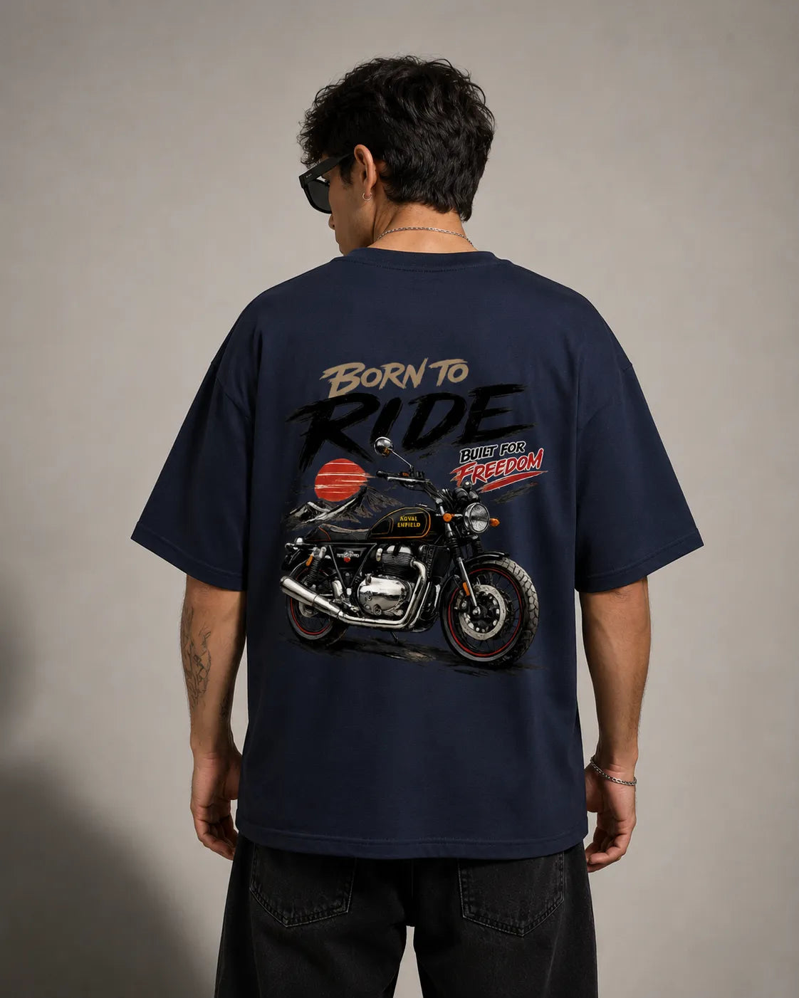 DRAVENYX® Born To Ride oversized tee in Navy Blue — front view showing left chest moto-badge print and drop-shoulder silhouette — back view with full-panel moto-art graphic and 'Born To Ride / Built For Freedom' DTF print
